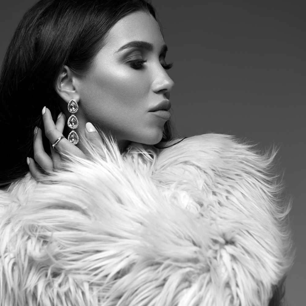 Elegant woman in fur coat and crystal drop earrings