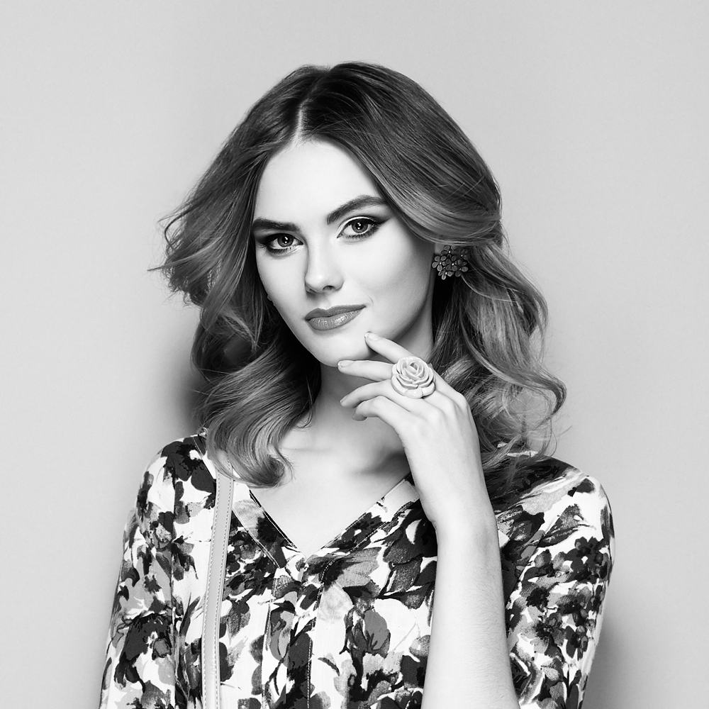 Stylish woman in floral dress with rose ring and wavy hair